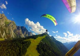 Der Tandempilot von Fly-Stubai fliegt über ein wunderschönes Bergpanorama während dem Tandem Paragliding im Stubai - Höhenflug.