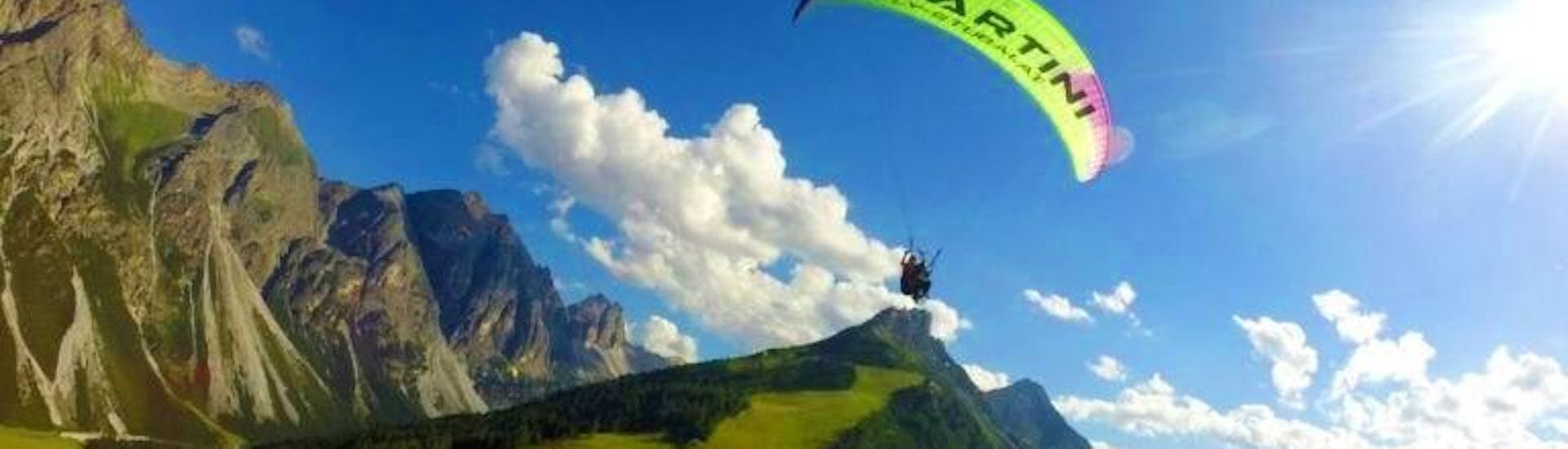 Der Tandempilot von Fly-Stubai fliegt über ein wunderschönes Bergpanorama während dem Tandem Paragliding im Stubai - Höhenflug.