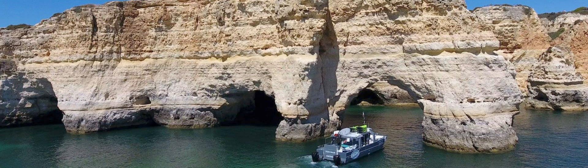 The catamaran operated by SeaAlgarve Albufeira is making its way along dramatic rock formations on the Algarve coast during the Benagil Boat Tour with Kayak or SUP.