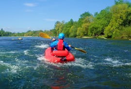 Tijdens de Rafting in een FUNYak op de Rijn - Stromende Rijn met Rheinraft, peddelt een deelnemer over de prachtige rivier de Rijn.