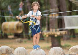 Parcours accrobranche en Ardèche - Circuit Maxi Pitchoun avec Accroche toi aux branches Ardèche Un enfant marche sur des plots pendant son Parcours Accrobranche - Circuit Maxi Pitchoun avec Accroche toi aux branches.