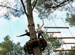 Dos niñas están en una plataforma en los árboles, listas para comenzar su día en el parque de aventuras - Ruta Discovery, con Accroche-toi aux branches.