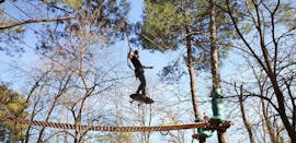 A man is surfing in the air during an obstacle of Adventure Park - Sports Route with Accroche toi aux branches.