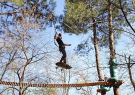 Abenteuerpark in Ardèche - Sportaktivität mit Accroche toi aux branches Ardèche Ein Mann in der Luft während eines Hindernisses des Adventure Park - Sportaktivität von Accroche toi aux branches.