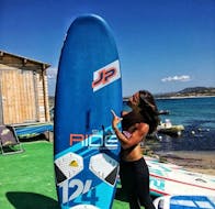 A woman is ready to go into the water with her SUP at the SUP rental with 2 Sides Porto Pollo.