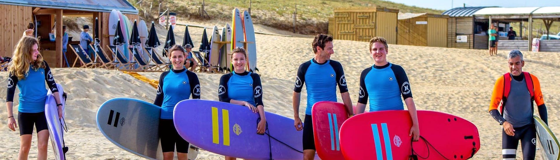 Eine Gruppe von Surfern macht sich mit ihrem Board unter dem Arm auf den Weg zum Surfkurs – Culs Nus Beach – Alle Levels mit Hossegor Surf Center.