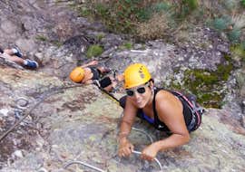 Klettersteig Pont du Diable in der Ardèche mit Les Intraterrestres Ardèche Eine Frau klettert während ihrer Via Ferrata-Aktivität in Ardèche - Pont du Diable mit Les Intraterrestres auf einen Felsen.