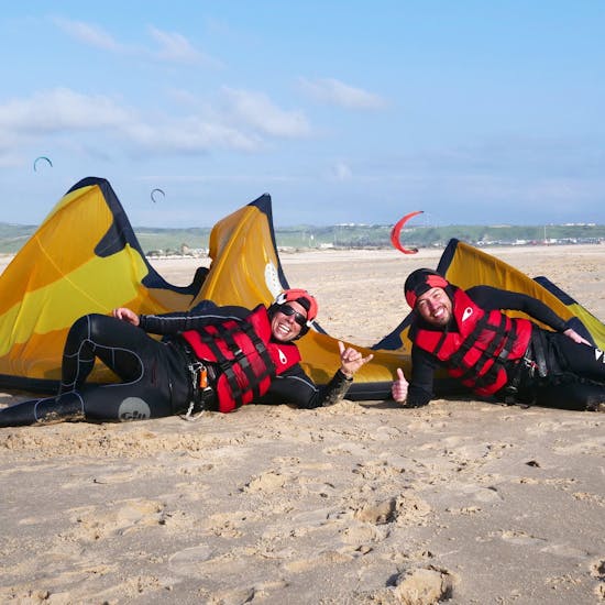 Two customers of Addict kite school are relaxing on the beach after their semi-private kitesurfing lessons for all levels.