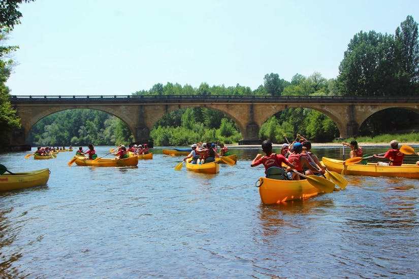 Holidaymakers are paddling on the Dordogne River during their 9 km canoe trip with Canoës Loisirs Dordogne.
