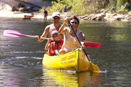 Una coppia e il loro bambino pagaiano sul fiume Dordogna durante il tour in canoa di 9 km con Canoës Loisirs Dordogne.
