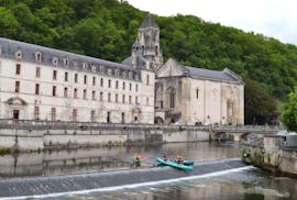 Gli amici pagaiano sul fiume Dronne nel mezzo dell'incantevole villaggio di Brantome durante la loro Fontaine d'Amour - tour in canoa di 8 km con Allo Canoës Dordogne.
