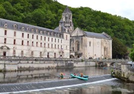 Friends are paddling on the Dronne river in the middle of the charming village of Brantome during their Fontaine d'Amour - 8km canoeing tour with Allo Canoës Dordogne.