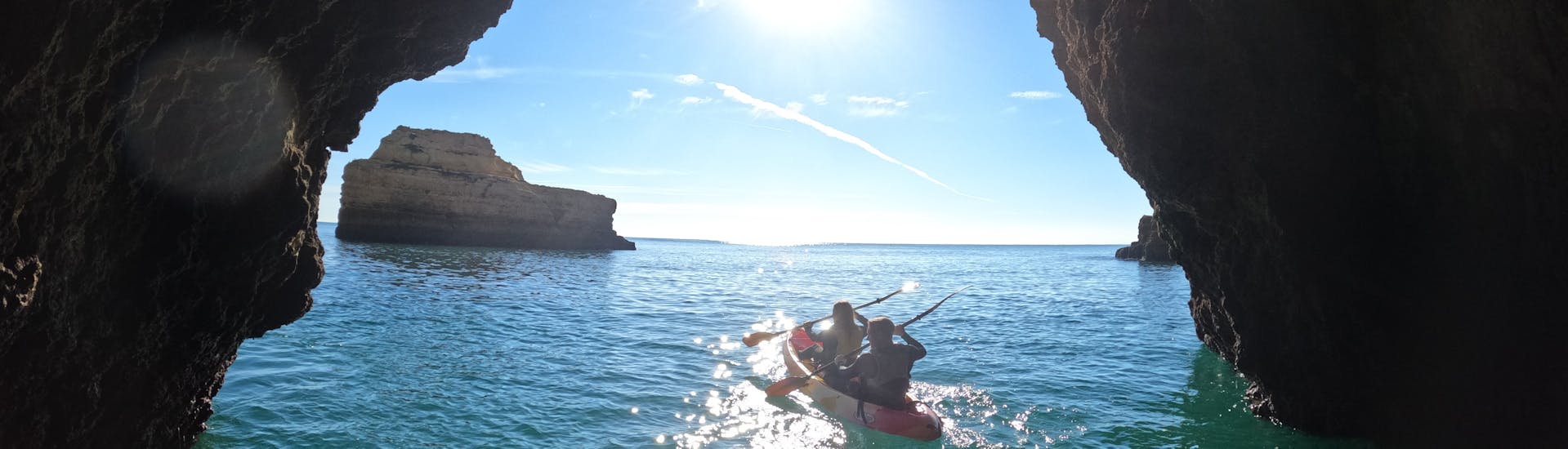 Una pareja navega en kayak por la costa de Albufeira con Kayak & SUP Albufeira y explora una de las muchas cuevas.
