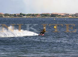 Una persona surfeando su cometa en el agua durante las clases semiprivadas de kitesurf en pareja para principiantes con Unikite Leucate.