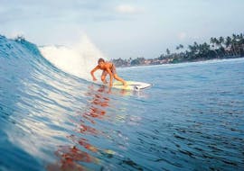 A surfer stands confidently on his surfboard and rides a wave during his Private Surfing Lessons incl. video analysis - All Levels of Latas Surf.