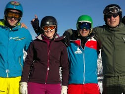 Four adults are holding each other during their adult and teen lessons for beginners with Hedi's Skischule Saalbach-Hinterglemm.