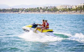 Dos amigos disfrutan del Jet Ski Tour en el agradable mar junto con Estación Náutica Costa Daurada durante el JCircuito en moto acuática en la Playa de Levante.