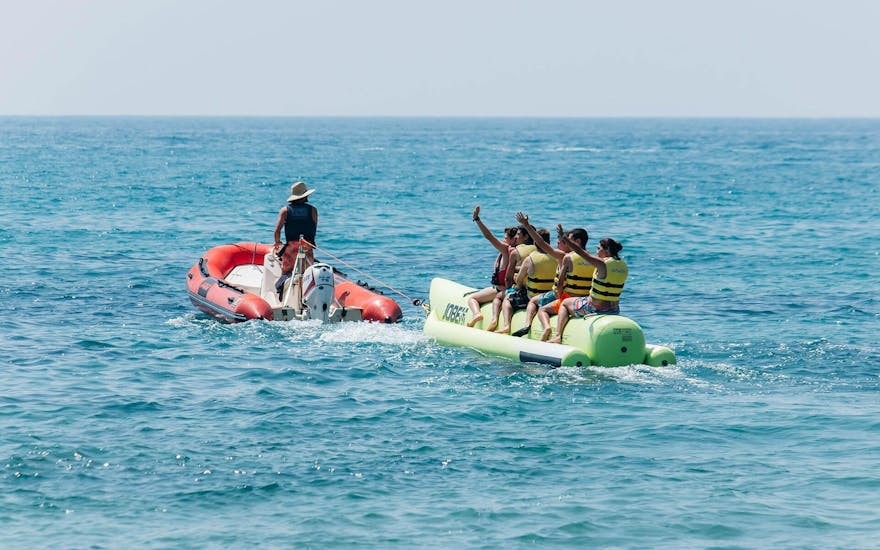 A group of friends let themselves be pulled by the boat through the sea during a Banana Boat in Salou organized with Nautic Parc Costa Daurada.