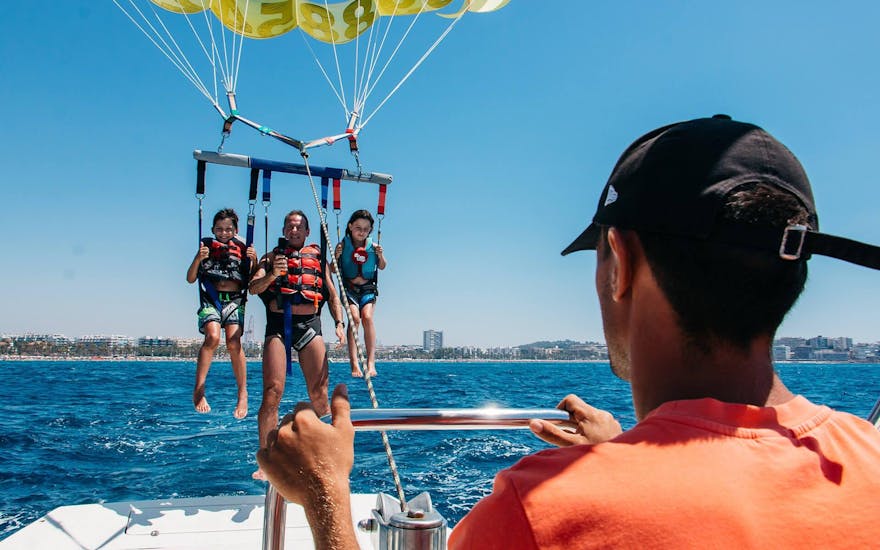 A family enjoys the beautiful views over the sea during Parasailing in Salou and Cambrils organized by Nautic Parc Costa Daurada.
