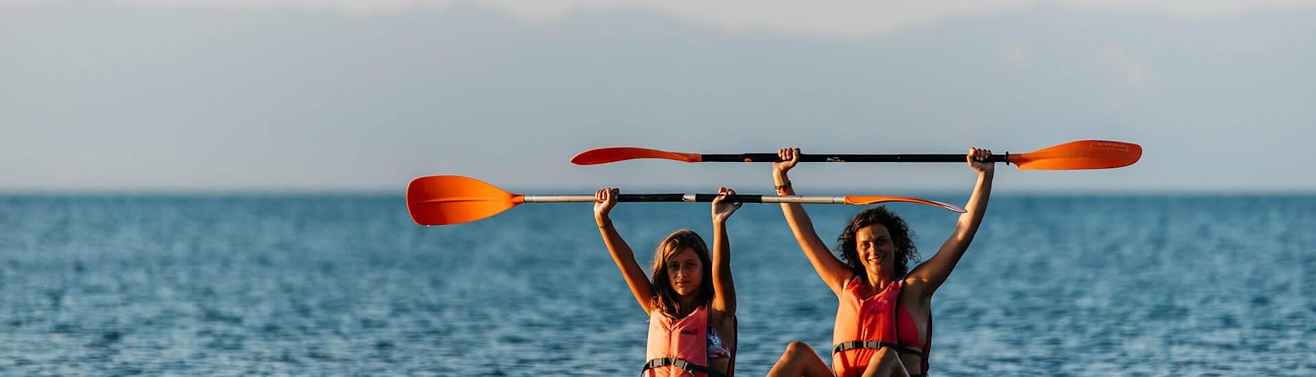Una pareja disfruta el Alquiler de Kayak en Salou y saltan al agua junto con Estació Nàutica Costa Daurada.