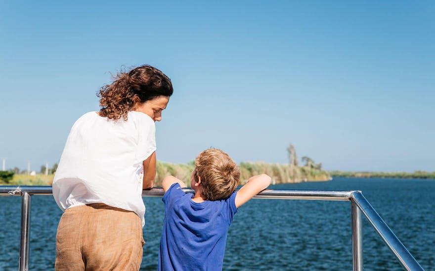 Een moeder en haar zoon genieten van het geweldige uitzicht tijdens een boottocht op de Ebro Delta rivier georganiseerd door Nàutic Parc Costa Daurada.