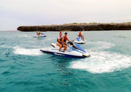 A couple enjoys the trip over the turquoise blue sea during the Jet Ski Rental in Cala Bona, offered by Sea Sports Mallorca.