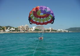 Two friends are sitting relaxed in the harness and are waiting to take off during the Parasailing in Cala Bona, offered by Sea Sports Mallorca.