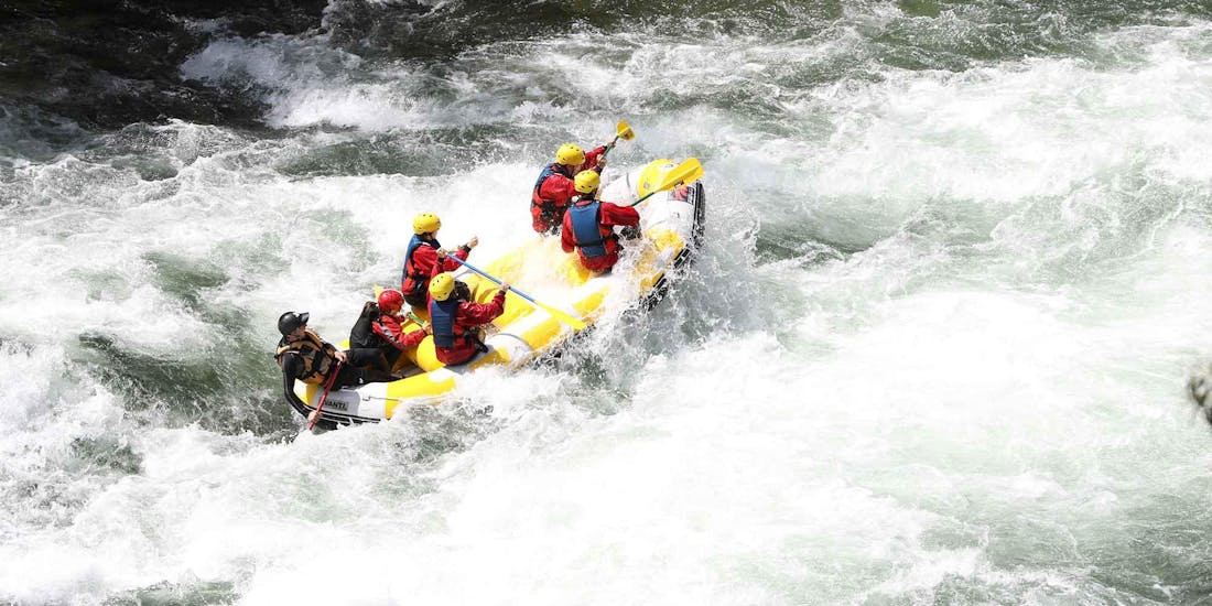 During the Class IV Rafting on Rio Paiva in Arouca Geopark with Clube do Paiva, a group of rafters is navigating through a massive rapid under the instruction of their experienced guide.