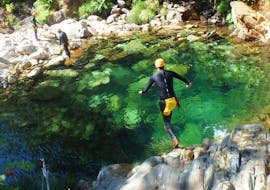 While Canyoning in Rio Frades in Arouca Geopark with Clube do Paiva, a participant jumps into the emerald green water of a natural pool.
