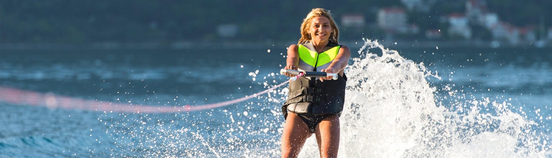 Une femme est tirée par un bateau pendant son Cours de ski nautique sur le lac d'Annecy avec Le Spot.