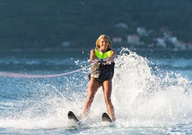 Eine Teilnehmerin wird beim Wakeboarden hinter einem Boot hergezogen beim Wasserski Kurse auf dem Annecy See mit Le Spot Annecy.