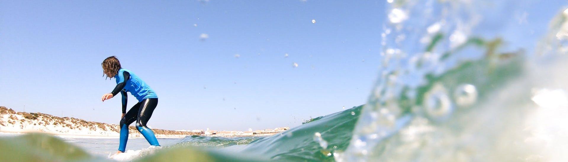 Beim Aufbau-Surfkurs an der Praia da Gamboa in Peniche mit Go4Surf Peniche erwischt ein junger Surfer eine gute Welle.