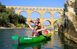 Una coppia si diverte pagaiando sul Gardon grazie al noleggio di una canoa per percorso di 8 km presso il Pont du Gard con Kayak Vert.