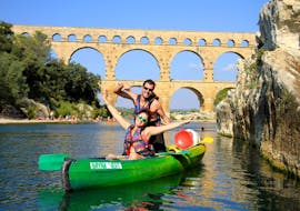 A couple is having fun while paddling on the Gardon thanks to their 8km Canoe Rental by the Pont du Gard with Kayak Vert.