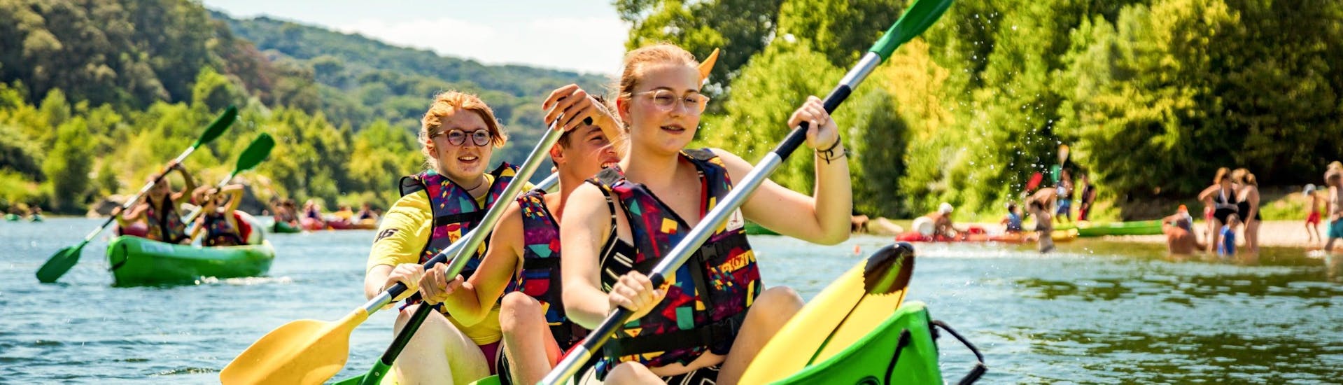 Tres amigos están aprovechando su alquiler de canoas de 8 km por el Pont du Gard para remar en el Gardon y pasar un buen rato, gracias a Kayak Vert.