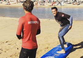 Clases privadas de surf en la playa de Carcavelos cerca de Lisboa con Lisbon Surfers. Un joven practica la técnica correcta de surf de Lisbon Surfaris durante una de las clases particulares de surf en la playa de Carcavelos, cerca de Lisboa.