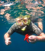 Un garçon admire une étoile de mer sous l'eau pendant l'excursion de plongée en apnée en bateau depuis la plage de Santa Barbara organisée par Hercules Marine Activites Corfu.