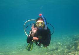 A participant or the Discover Scuba Diving at Santa Barbara Beach for Beginners with Hercules Marine Activities Corfu is posing for a photo during her first scuba dive in Corfu.