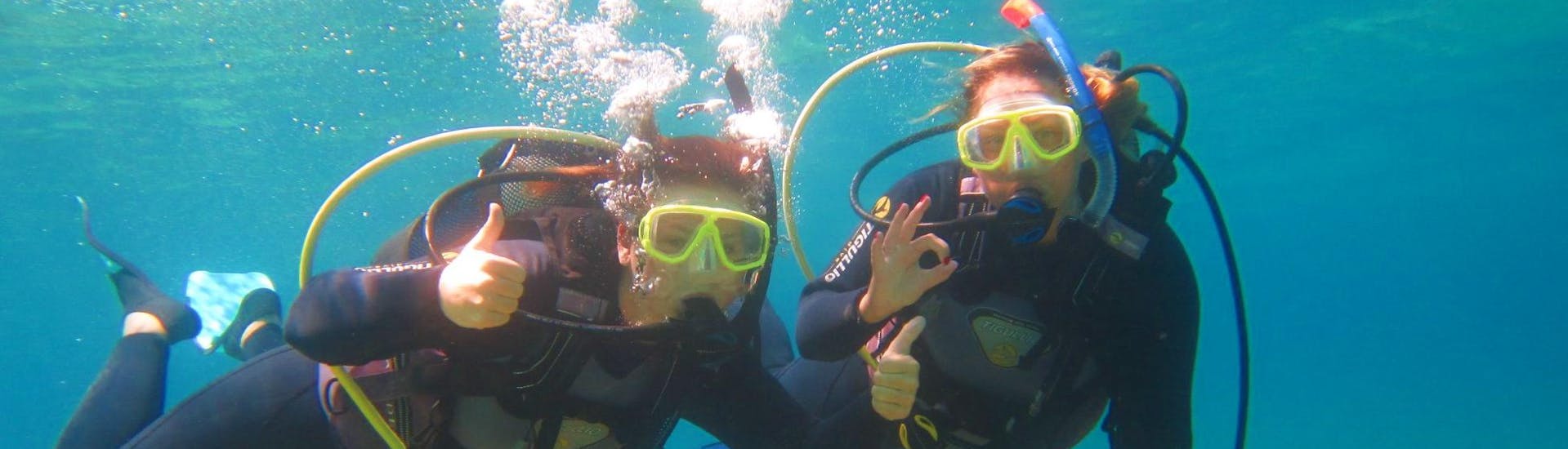 Zwei Freundinnen erkunden die Unterwasserwelt Korfus während ihres CMAS*-Tauchkurses für Anfänger mit Hercules Marine Activities Corfu.