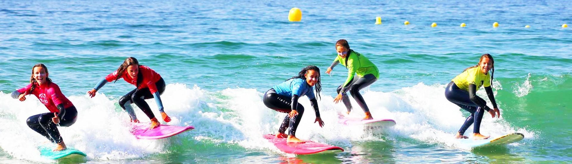 A group of surfers enjoy their successful Surfing Lessons at Playa Grande de Bastiagueiro , organized by Prado Surf.