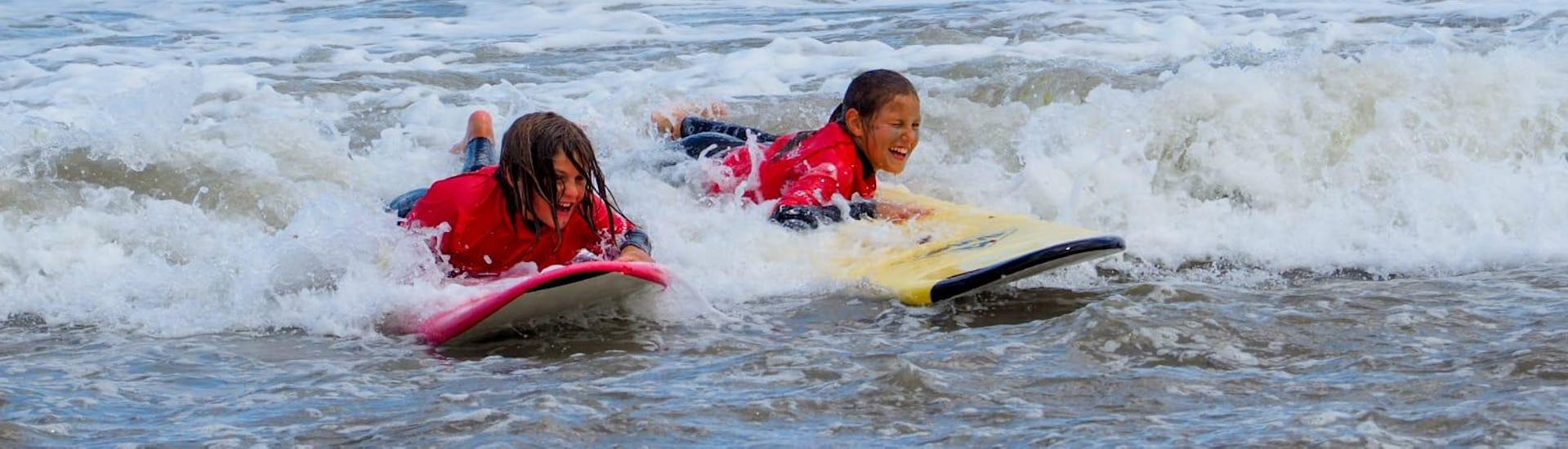Two children visibly have fun in the water during their Private Surfing Lessons at Playa Grande de Bastiagueiro, organized by Prado Surf.