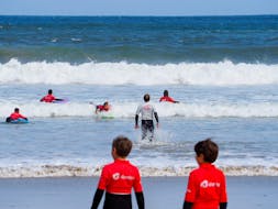 A surf instructor from Prado Surf gets into the water to help his course participants during their Surfing Lessons at Playa de Sabón for all Levels.
