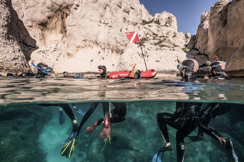 A family is exploring the Mediterranean seabed while Snorkeling in Calanques National Park from Marseille with Le Bateau Jaune.