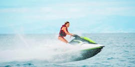 Une jeune fille profite de la vitesse des vagues lors de sa location de jet ski sur la plage de Kamari à Santorin avec Kamari Beach Watersports Santorini.