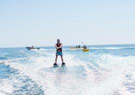 With the help of a certified instructor from Kamari Beach Watersports Santorini, a young man is waterskiing at Kamari Beach in Santorini.