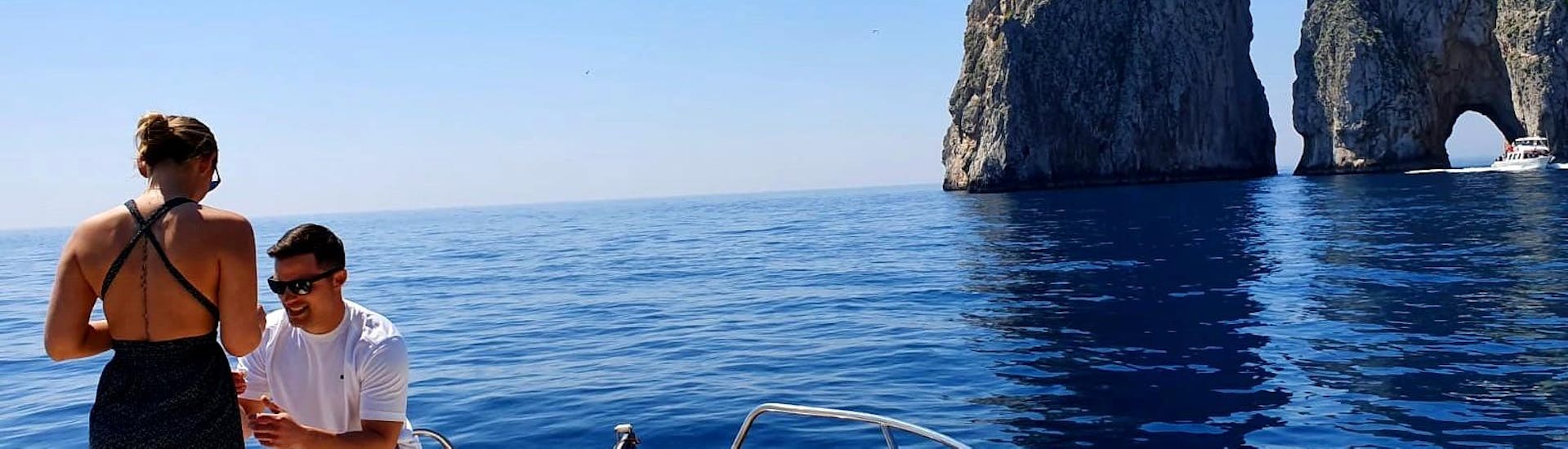 A man is proposing to his fiancé during the Private Boat Trip from Sorrento to Capri.