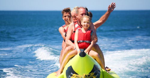 Banana Boot an der Praia de Armação de Pêra mit Moments Watersports Algarve Eine Familie genießt ihre Fahrt auf dem Bananenboot während einer Spaßbootfahrt an der Praia de Armação de Pêra mit Moments Watersports Algarve.