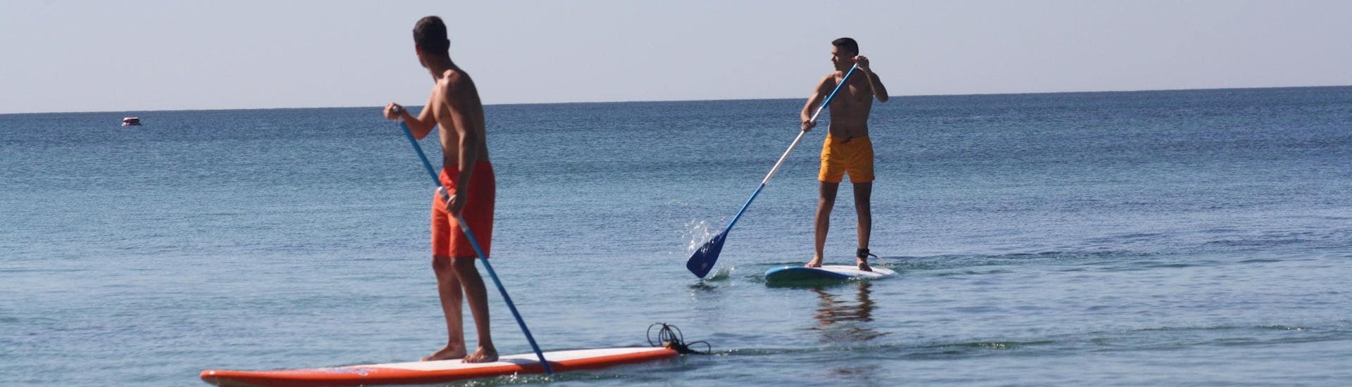 Une photo de deux hommes lors d'une expérience de SUP Stand Up Paddle à Algarve Armacao de Pera.