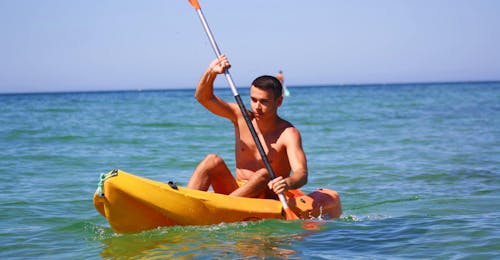 sea-kayak-rental-at-praia-de-armacao-de-pera-moments-watersports-algarve Un joven explora la preciosa costa de Algarve durante su alquiler de kayak en Praia de Armação de Pêra desde Moments Watersports Algarve.