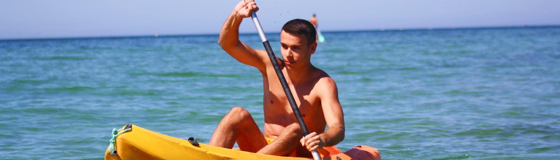 Un joven explora la preciosa costa de Algarve durante su alquiler de kayak en Praia de Armação de Pêra desde Moments Watersports Algarve.